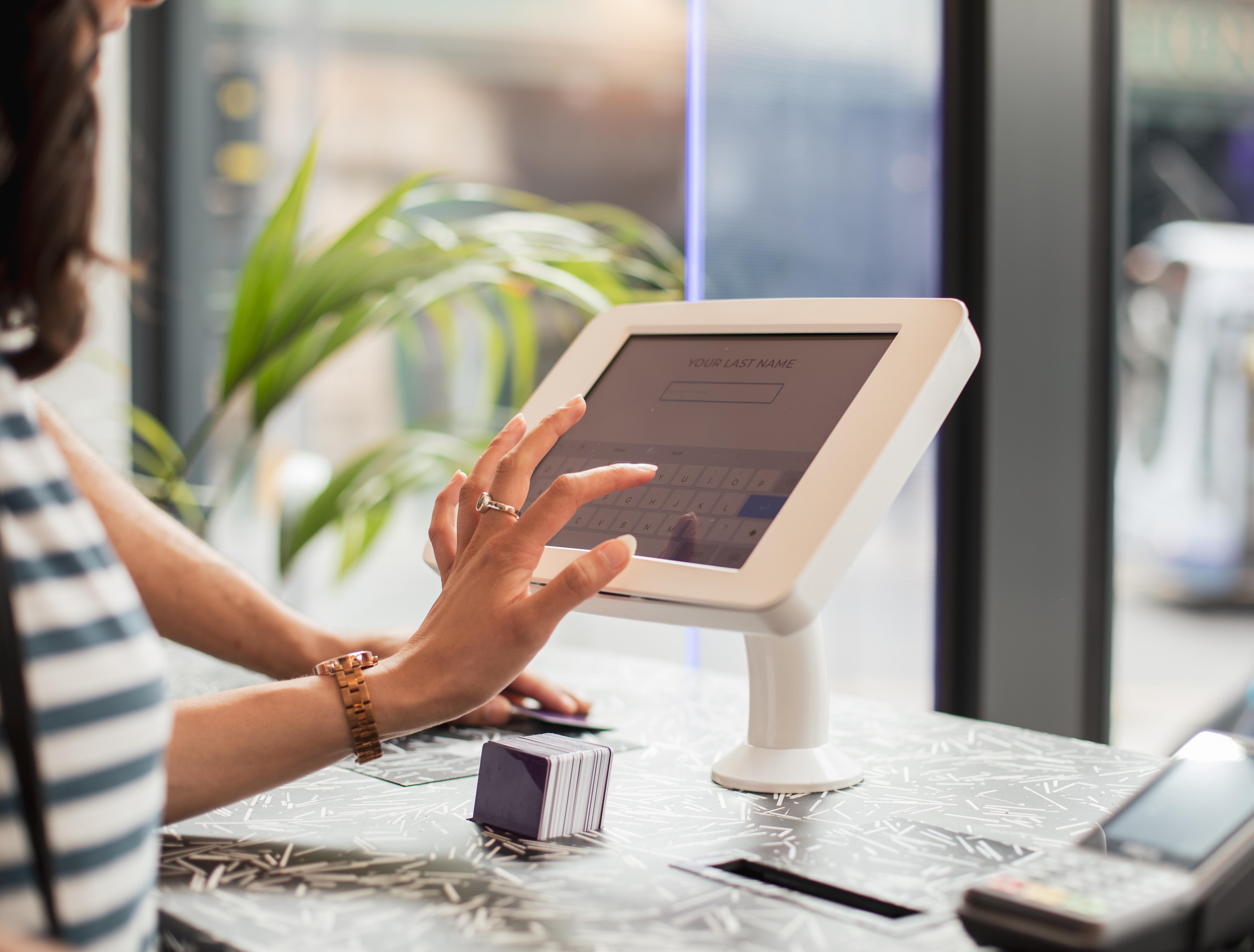 Yotel Glasgow Luaran gambar A woman using a tablet to enter her name at a check-in desk