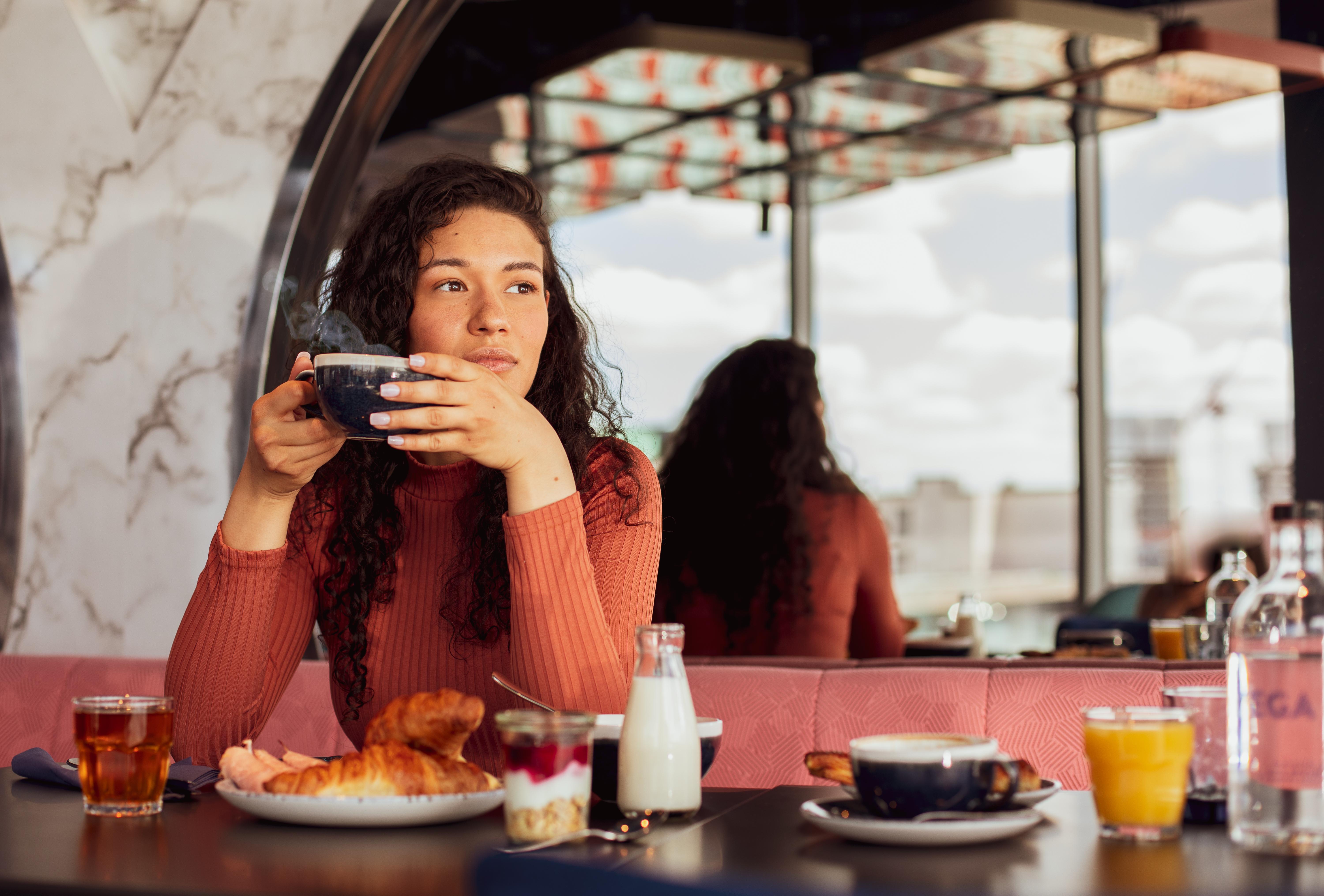 Yotel Glasgow Luaran gambar A woman having breakfast at a cafe.